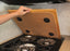 Camco 43521 Stove Top Cover Oak Accents (TM); Length (IN) - 17-1/2 Inch  Width (IN) - 19-5/8 Inch  Color - Oak  Material - Hardwood  With Silence Stove Rattle - Yes  Quantity - Single With English Language Packaging